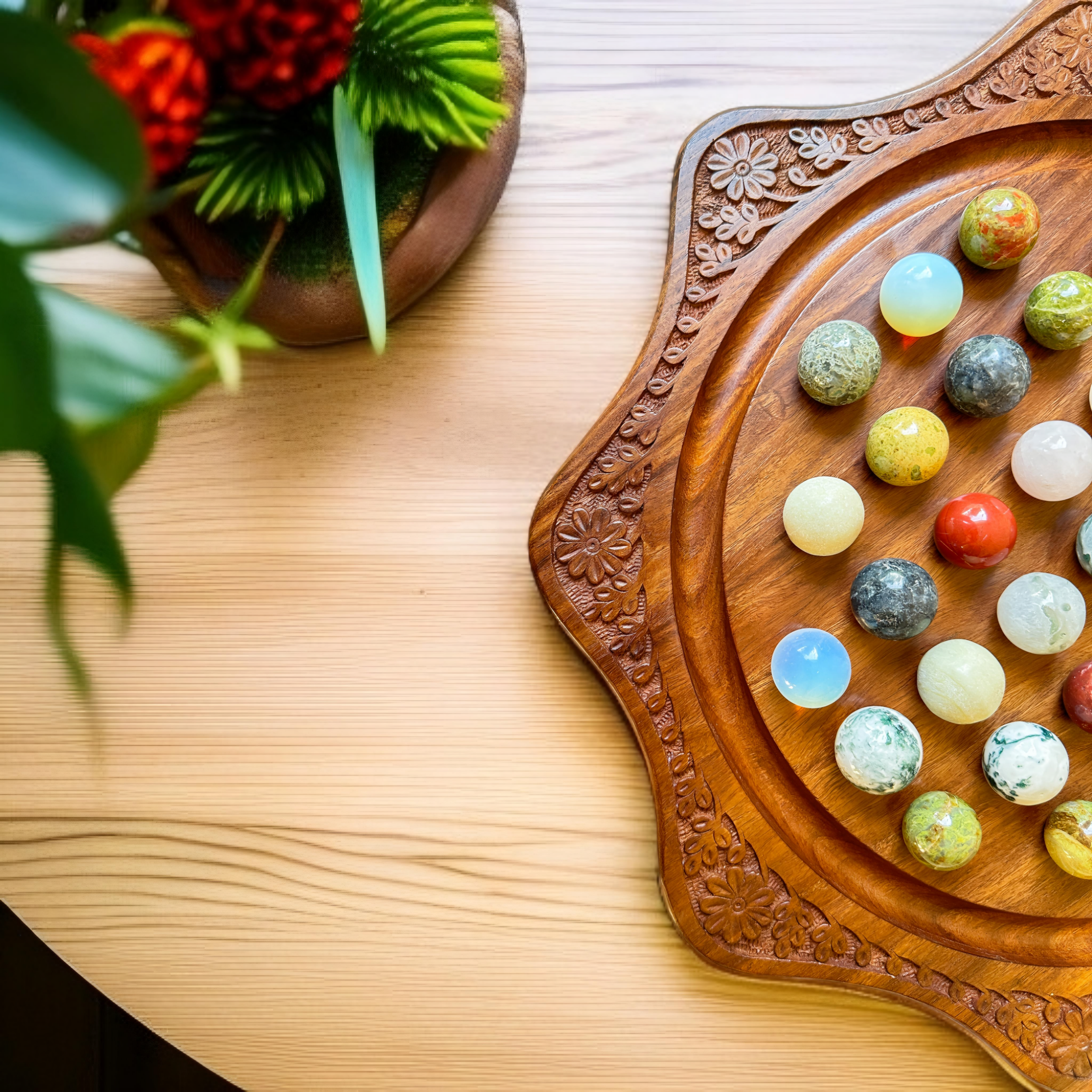 Handmade solitaire game set with a wooden board and earthy natural marbles, perfect as a unique tabletop centerpiece.