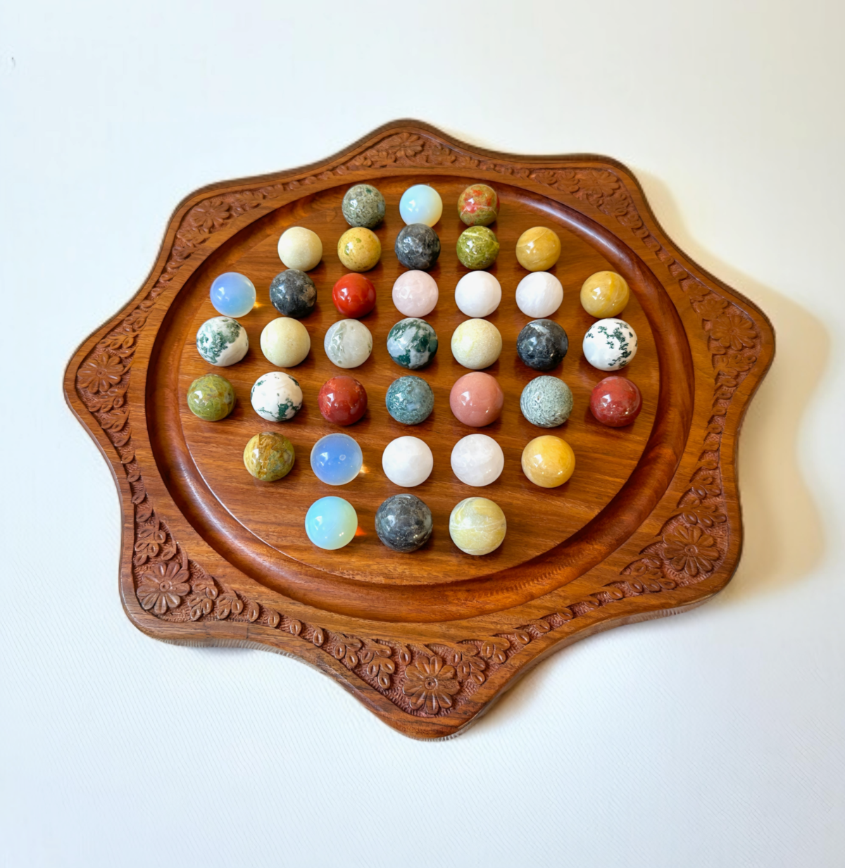 Classic marble solitaire game made of handmade polished wood, paired with vibrant natural marbles for engaging play